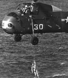 A helicopter lifts astronaut Gus Grissom to safety.
