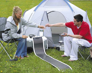 Two recreational campers use a folded out solar charger as a power source