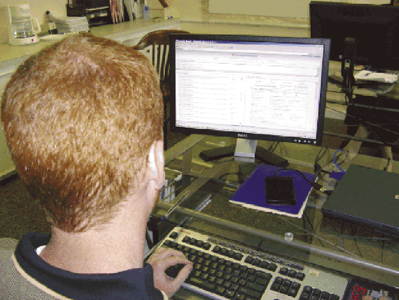 View over a user’s shoulder of AIOXFinder software displayed on a monitor