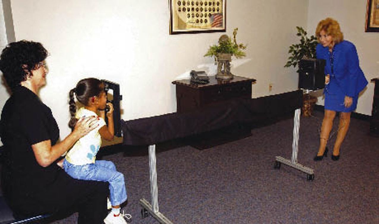 A specialist from the Vision Research Corporation photographs a child’s eyes. 