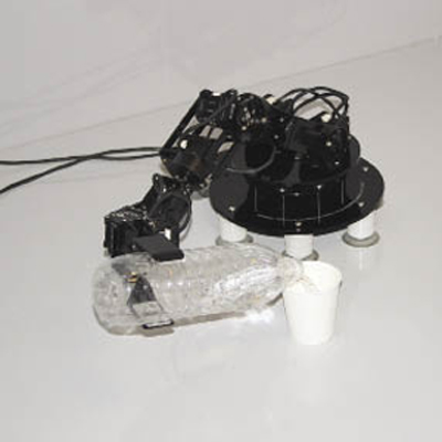 A small robot claw pouring water from a bottle into a cup 