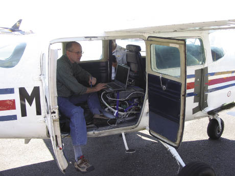 Scientist with sensor equipment in airplane Scientist with sensor equipment in airplane