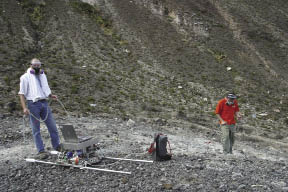 Scientist with sensor equipment at volcano site Scientist with sensor equipment at volcano site