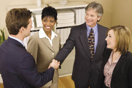People shaking hands in business setting 