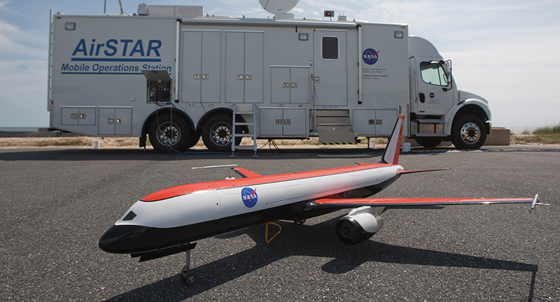 A small-scale test aircraft on tarmac with a truck in the background