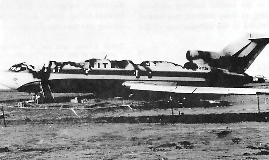 A black and white image of an airliner on the ground with the entire top burned off after a crash