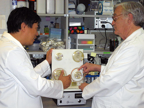 Two scientists examine a bioreactor