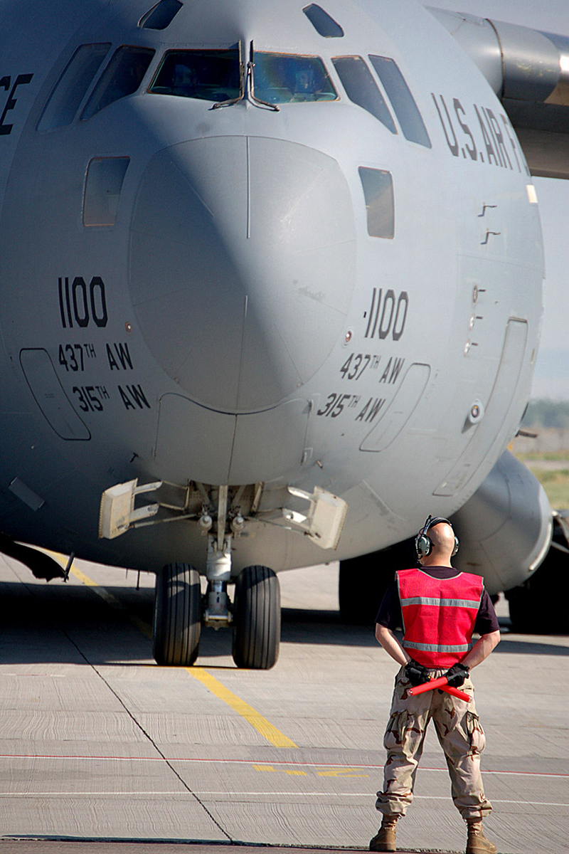 Ground crew directs military aircraft on the tarmac