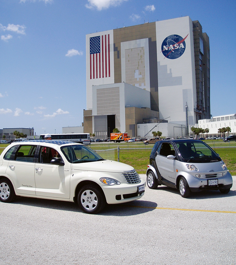 Two of Hybrid Technologies’ electric vehicles are displayed in front of Kennedy Space Center