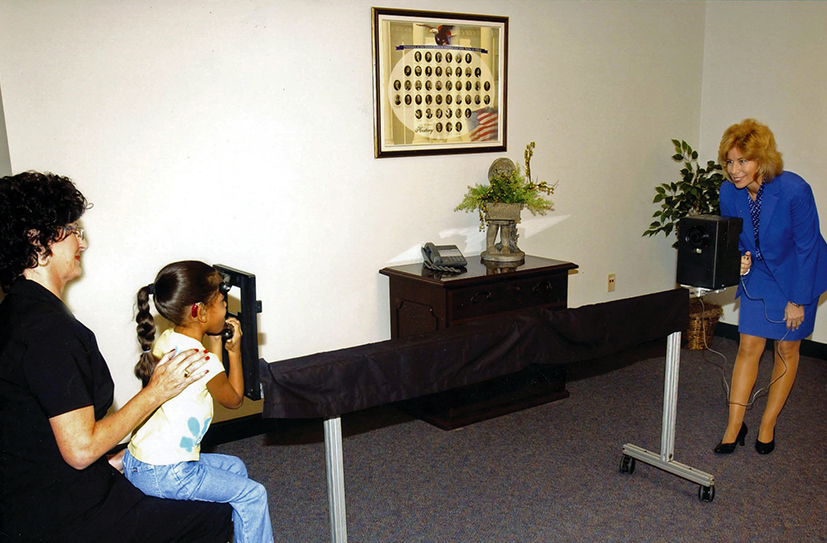 A specialist from the Vision Research Corporation photographs a child’s eyes