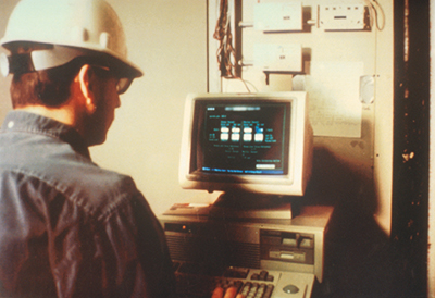 A plant technician checks an industrial process stream on a monitor