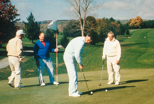 Four men playing golf on a golf course