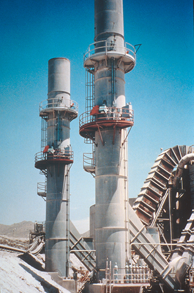 A pair of industrial smokestacks equipped with GE Reuter-Stokes Stak-Tracker gas analyzers