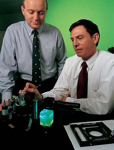 Dr. Patrick Huddie, CEO and Dr. Wayne Moore, President of Microcosm, Inc., display the FarField-2 Laser