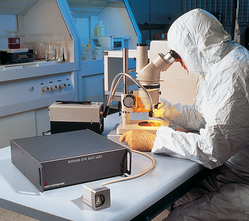 Femtometrics, Inc.'s NVR-200 in foreground in a cleanroom with a scientist looking into a microscope