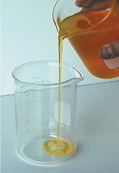 Amber colored liquid being poured into a measuring cup