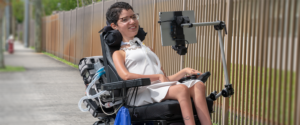 Girl in a wheelchair with a laptop display on a mount