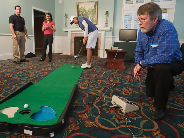 Langley Research Center engineer Alan Pope watches people try his putting green-turned-biofeedback device