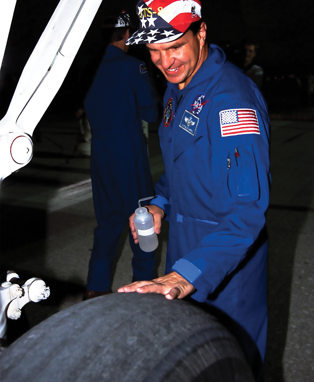 Astronaut Michael Bloomfield inspects a Space Shuttle tire