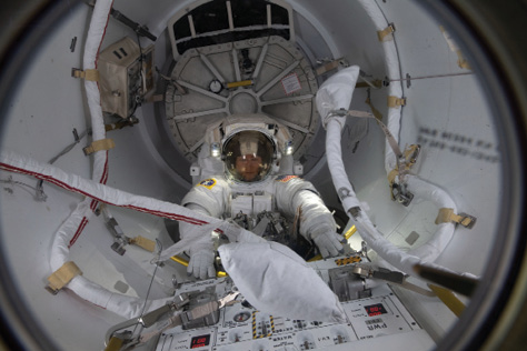 U.S. astronaut Christina Koch in a spacesuit enters an airlock on the space station