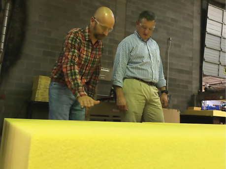 Boyd Corporation manager James Williams and local Congressman Bruce Westerman look at bright yellow Solimide panels