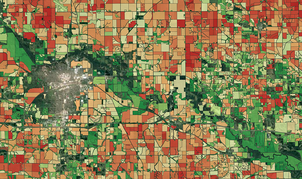 This map shows the aggregated soil carbon level for each agricultural field around Marshaltown, Iowa, compared to the regional average, with reds indicating lower carbon content and greens showing more carbon.