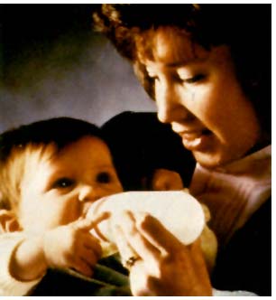 of a woman feeding a baby the Nenatal formula