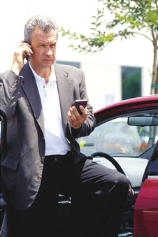 a gentleman using the web time-management tool from his parked car. Image shows the versatility of the product