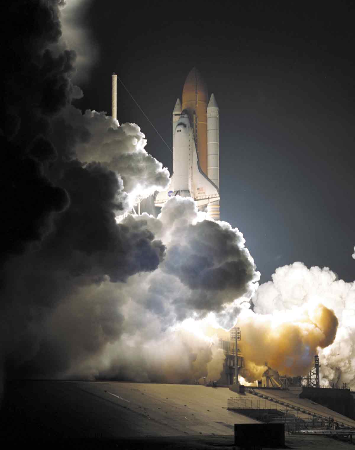 of space shuttle blasting off at night
