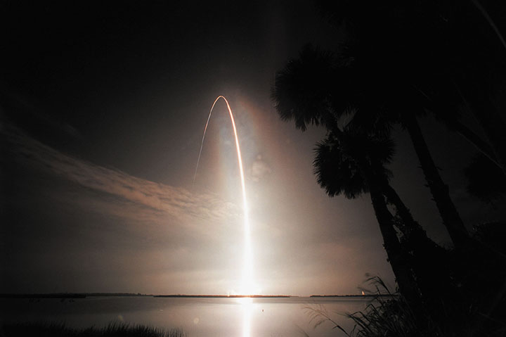 of space shuttle leaving a rainbow affect of smoke as fades away