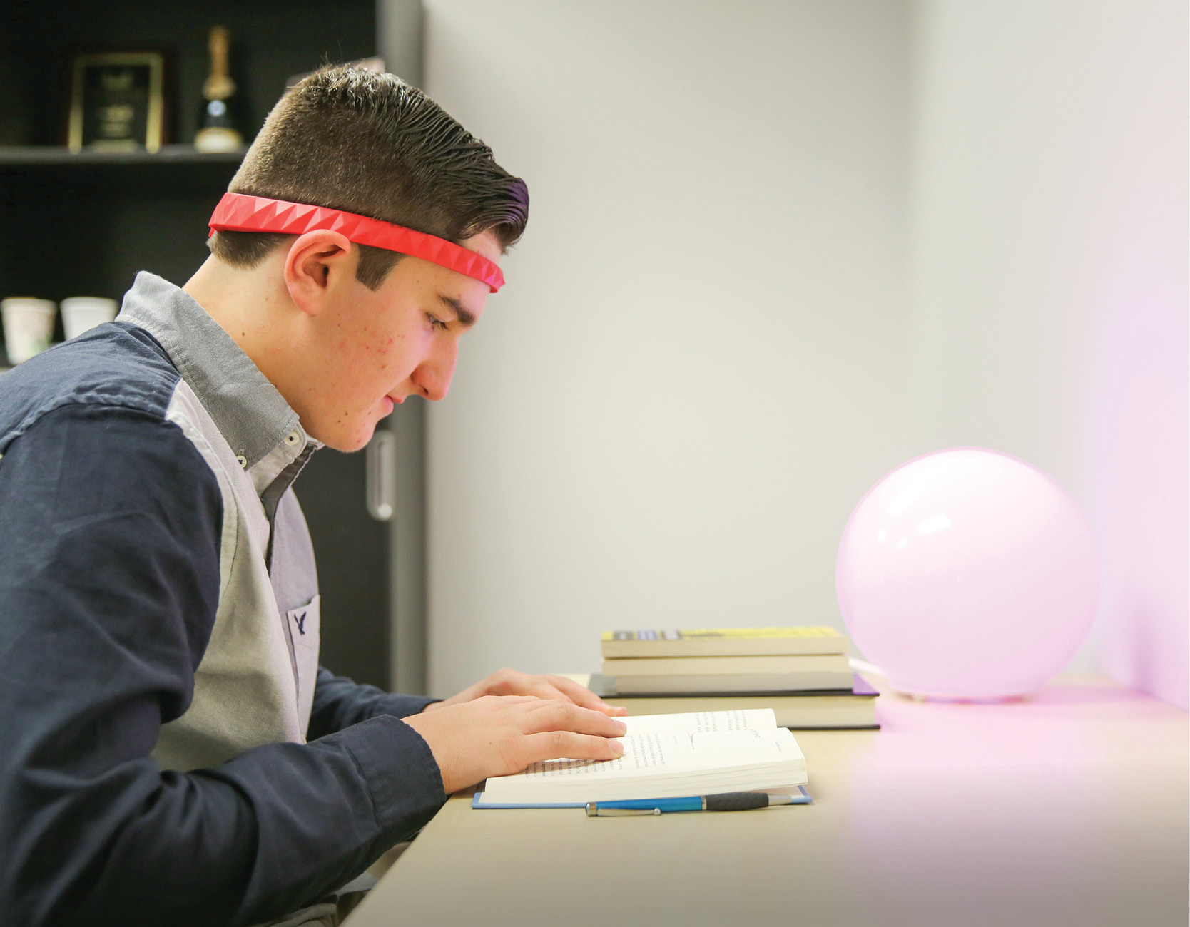 A student reading while wearing BrainCo’s LUCY headband 