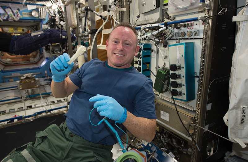 Astronaut holding 3D printed tool