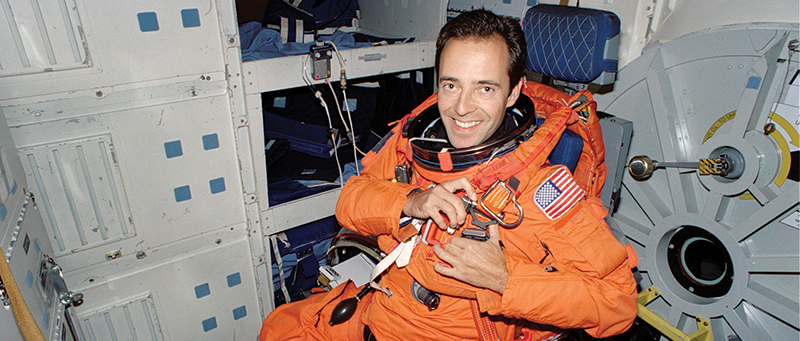 An astronaut sits in a Space Shuttle seat