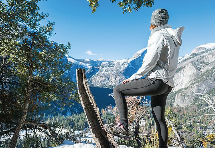 A woman on a mountain trail wearing Oros aerogel-lined outerwear