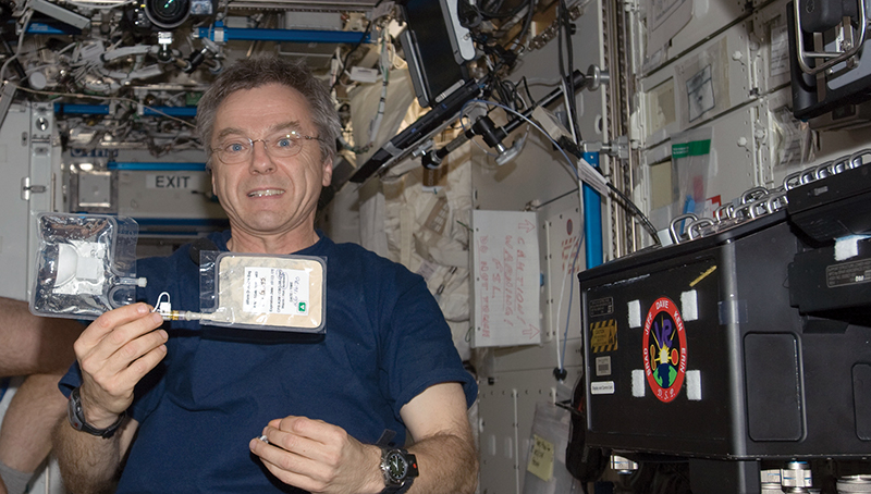 Canadian astronaut Robert Thirsk holding water test kit