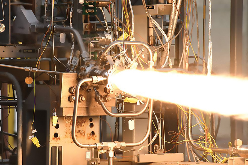 White flames shooting out of rocket engine combustion chamber in testing