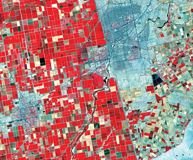 A satellite image of the U.S.-Mexico border combining visual and infrared bands