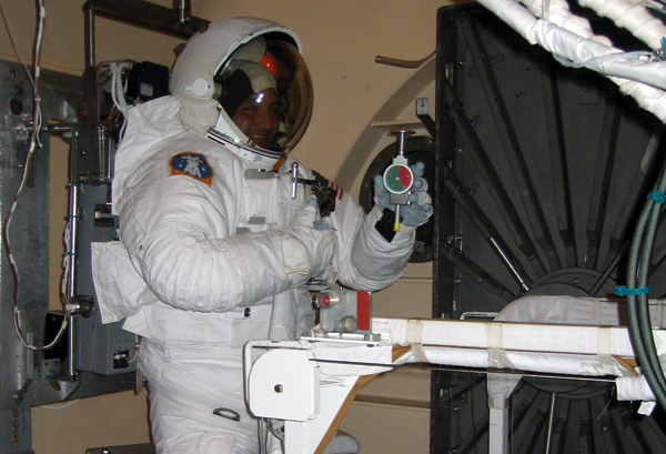 An astronaut displays the Rex Gauge durometer modified for space
