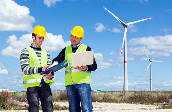 Two men in front of wind turbines