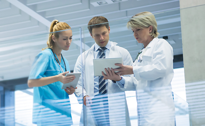 Doctors conferring while looking at a tablet computer