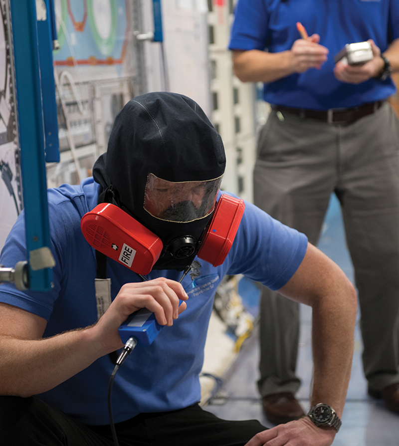 Two men wearing emergency breathing devices