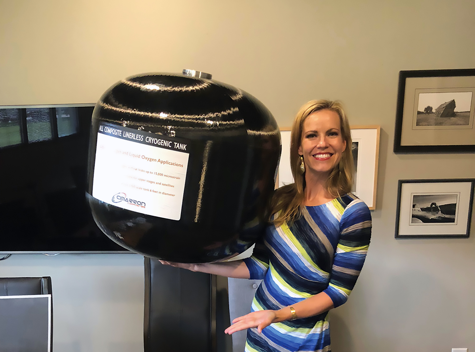 Woman holds large composite overwrapped pressure vessel easily in one hand