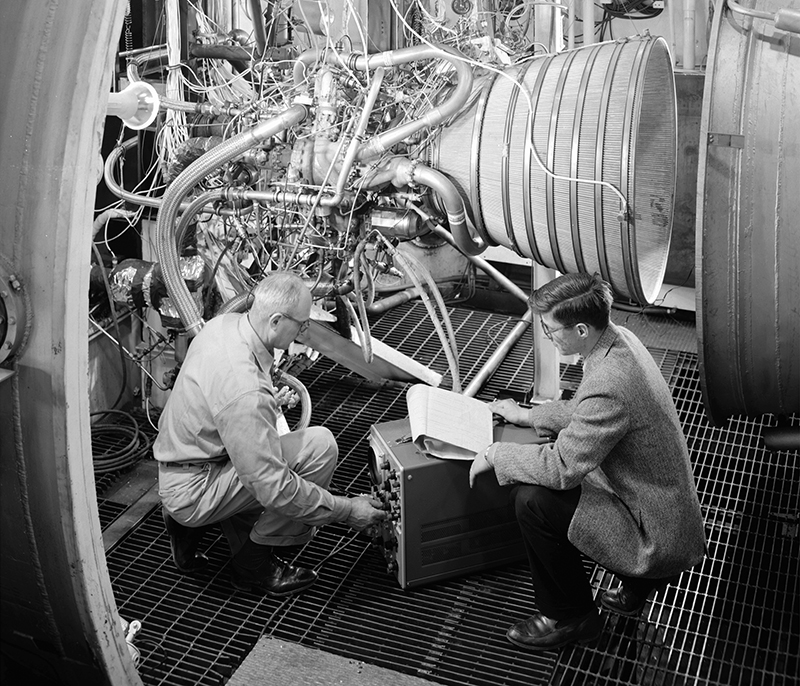 NASA engineers examine an early RL10 rocket engine