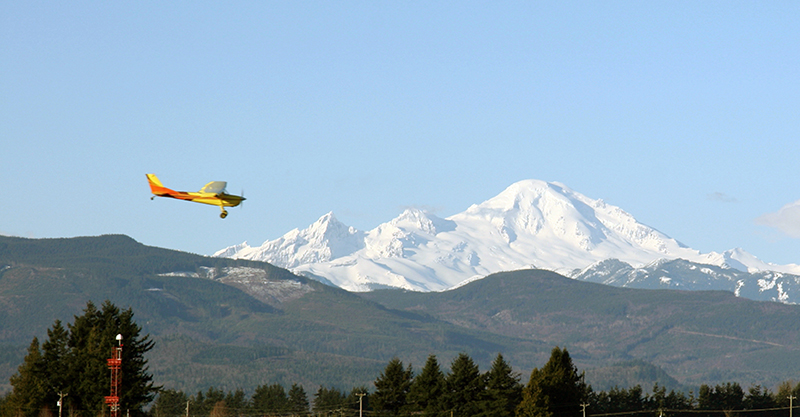 Small plane flying in front of mountains