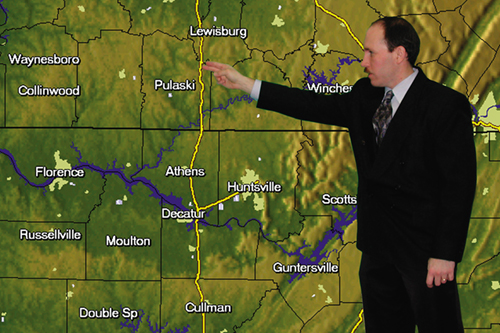 A meteorologist interacts with a map
