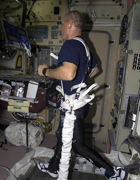 Astronaut Ken Bowersox runs on a treadmill using a loading harness