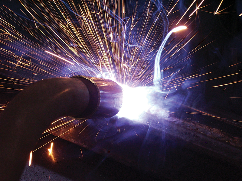 A welding torch emits bright intense light and sparks