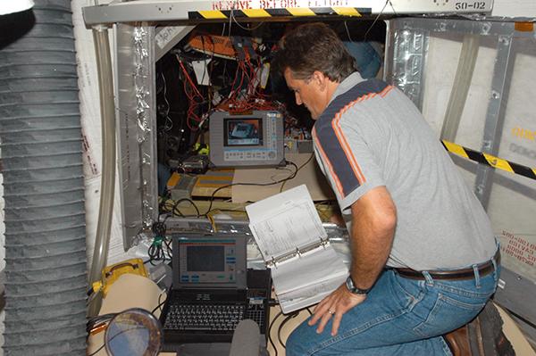 Engineer testing wiring in the Space Shuttle Discovery