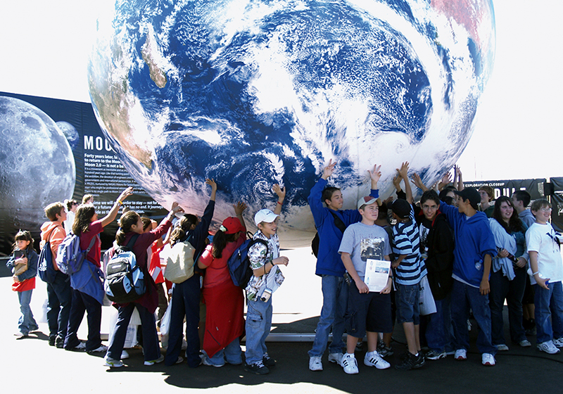 Children gathered under large globe