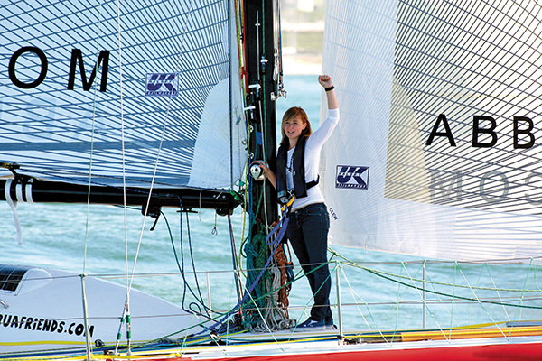 Young sailor stands on boat